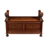 A carved oak monk's bench, early 20th century, the top with hinged lid and bold, carved lion form