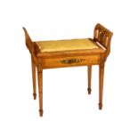 An Edwardian painted satinwood piano stool in the George III style, the hinged padded seat with