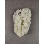 A modern Chinese white jade carving, depicting two boys beneath a lotus leaf, 6½in. (16.5cm.) high.
