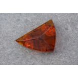 A 9ct yellow gold and amber brooch, cut to an unusual triangular shape and with visible