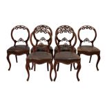 A set of six Victorian walnut balloon back dining chairs, the backs with pierced top rail with