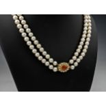 A two strand cultured pearl choker necklace, the two rows of evenly sized 6mm. pearls with a 9ct