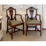 A pair of 19th century George III-style mahogany armchairs, the shield backs with pierced and