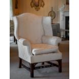 An 18th century style mahogany wingback armchair, probably 19th century, upholstered in cream