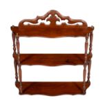 A Victorian set of walnut three tier hanging shelves, the Gothic pierced back over three