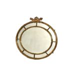 A large oval Regency style giltwood mirror, early 20th century, with crossed ribbon and reeded
