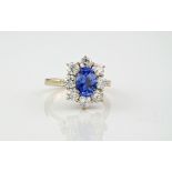 An 18ct yellow gold, fine sapphire and diamond cluster ring, the central sapphire weighing