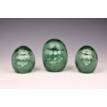 A graduated set of three Victorian glass dump weights with sulphide floral inclusion, each with a