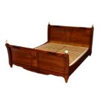A French antique style double bed, in cherrywood with faux-burr wood decoration, of sleigh bed form,