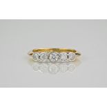 An 18ct yellow gold and diamond 5 stone ring, the stones held in an 18ct white gold rubover setting.