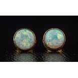 A pair of 9ct gold and opal stud earrings, the 7.5mm. cabochon opals of good colour and iridescence,
