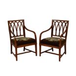 A pair of George III mahogany ebow chairs, the square backs with interlaced arches, over downswept