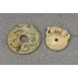 Two Chinese carved jade Pi discs, probably 19th century, the larger in shaded green jade, having