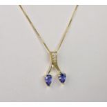 A 14ct gold, Tanzanite and diamond necklace, the pair of pear shaped Tanzanites on a twist drop set