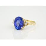 A 14ct yellow gold, tanzanite and diamond ring, the magnificent oval cut tanzanite measuring 11mm