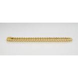 A 9ct yellow gold and diamond tennis bracelet, measuring 177mm in length.