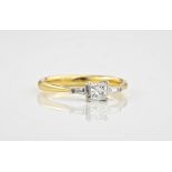 An 18ct yellow and white gold diamond trilogy ring, with a princess cut centre stone between two