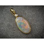 An 18ct gold, opal and diamond pendant, the oval, cabochon opal of good iridescence and orange,