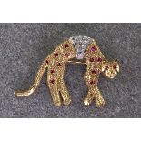 A 14ct gold cat brooch, with platinum detailing and studded with diamond chips. With ruby