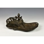 An Art Nouveau style bronze card tray, cast with a young maiden reading on naturalistic floral base,