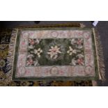 A small Chinese silk rug, late 20th century, the central sage green field with floral decoration,