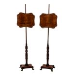 A pair of Regency mahogany and tulipwood pole screens, the shaped screens with original painted