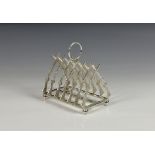 A modern silver plate novelty six division toast rack fashioned as crossed rifles, with central ring