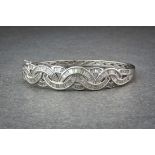 An 18ct white gold and diamond hinged bangle, en suite to lots 1273, 1274 and 1275, the graduated,