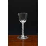 A mid-18th century airtwist wine glass, c.1750-60, with round funnel bowl and double series air