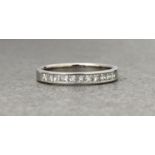 An 18ct white gold and diamond half eternity ring, channel set with eleven princess cut diamonds,