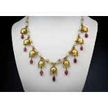 An Eastern 18ct gold, seed pearl and ruby necklet, the seed pearl and gold bead necklet suspending