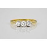 An 18ct yellow gold and diamond three stone ring, hallmarked London 1988, the centre 0.30ct