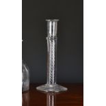 An antique airtwist glass candlestick, probably 19th century, the cylindrical nozzle above a plain