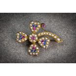 An antique 9ct gold, sapphire, ruby and seed pearl four leaf clover brooch, the clover outlined with