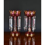 A pair of Victorian ruby glass table lustres, of typical form highlighted in gilt, each hung with