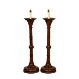 A pair of turned oak church candlestick lamps, mid-20th century, 36in. (91.5cm.) high plus fittings.