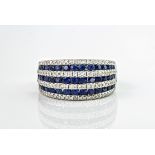 An 18ct white gold, sapphire and diamond ring, featuring 3 rows of royal blue round cut sapphires