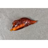 A Chinese carved amber fish snuff bottle, probably 20th century, 3½in. (8.5cm.) long.