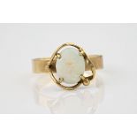 A vintage 9ct gold and opal ring, the white opal in an asymmetric open four claw setting, on a plain