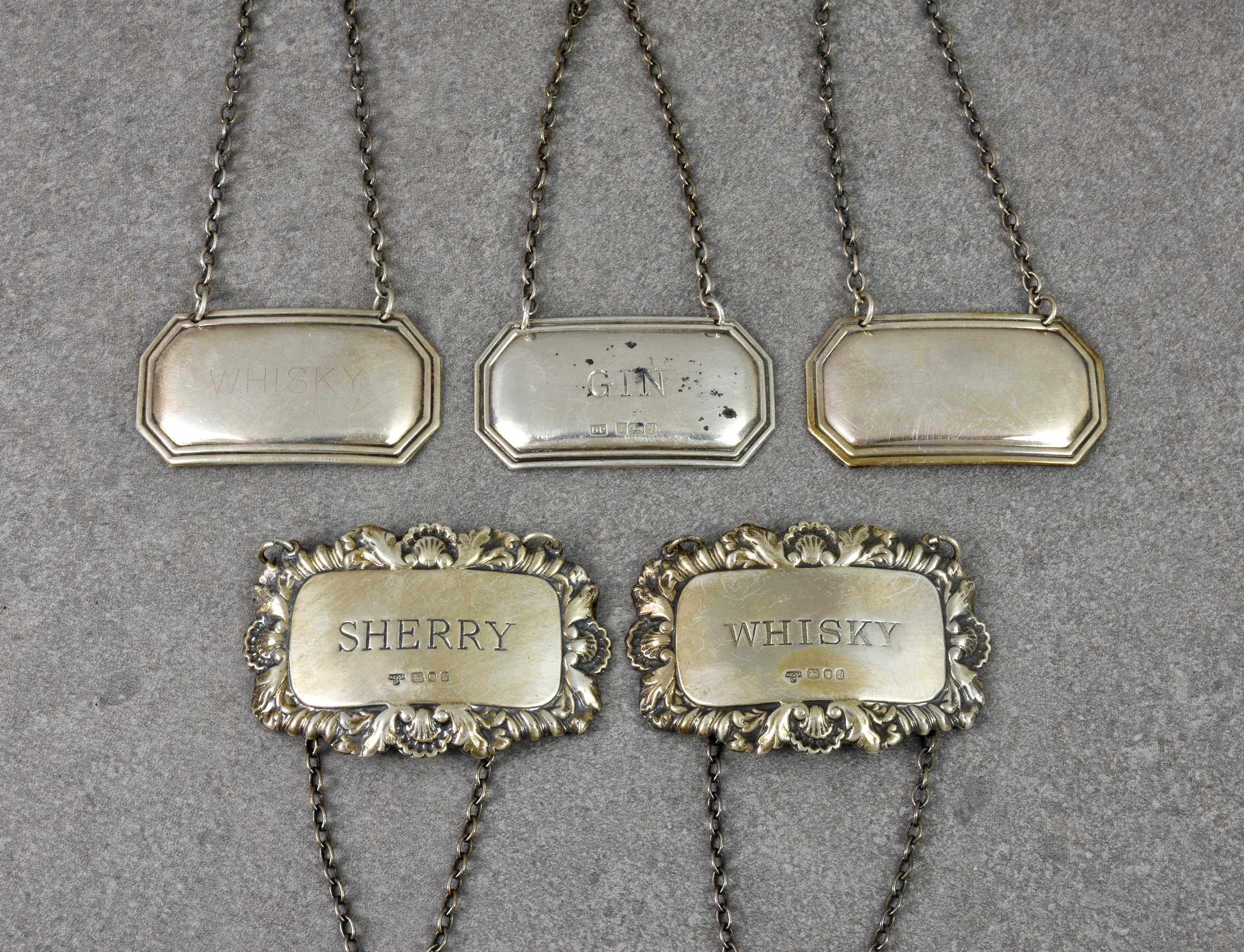 A collection of five vintage silver decanter labels, comprising of two by A Chick & Sons Ltd,