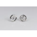 A pair of 18ct white gold and diamond ear studs, one 0.63ct VS2 diamond and one 0.6 SI1 diamond in