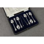 A cased set of six silver coffee spoons and sugar tongs, of unusual rat tail trefid design, Lee &