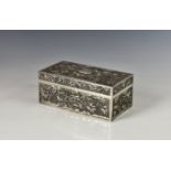 An Oriental silver cigarette or table box, apparently unmarked, of rectangular form with repoussé