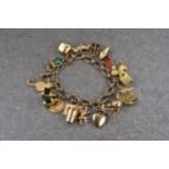 A 9ct gold charm bracelet, the fancy link chain measuring approximately 85mm in length with a