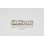 A 9ct white gold and diamond half eternity ring, featuring 11 round cut diamonds in a polished