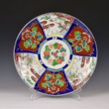 A large Japanese Imari porcelain charger, c.1900, painted in the typical palette with alternating