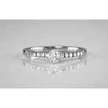 An 18ct white gold and diamond engagement ring, the central, brilliant cut stone weighing