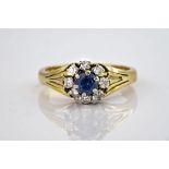 A 9ct yellow gold, sapphire and diamond cluster ring, the central round cut sapphire of