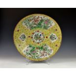 A large Chinese famille rose jaune charger, 19th century, painted with two large fan shaped panels