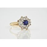 A 9ct yellow gold, sapphire and cubic zirconia cluster ring, the central, round cut sapphire